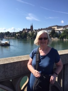 Ann on a bridge over the Rhine river in Basel with the Cathedral in the distance