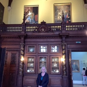 Ann in the Baronial Dining Hall showing the music gallery and more porcelain and paintings