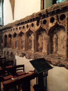 The old mediaeval stone reredos that used to stand behind the high altar now part of the wall of the side aisle