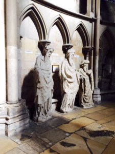 Three of about 30 ancient and very weathered statues  lining the side aisles of Rouen cathedral