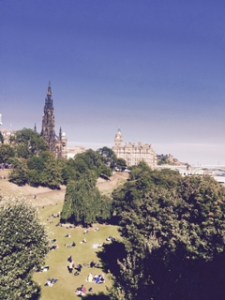 View from the Art Gallery square in Edinburgh with locals sun-baking on the lawns in the 